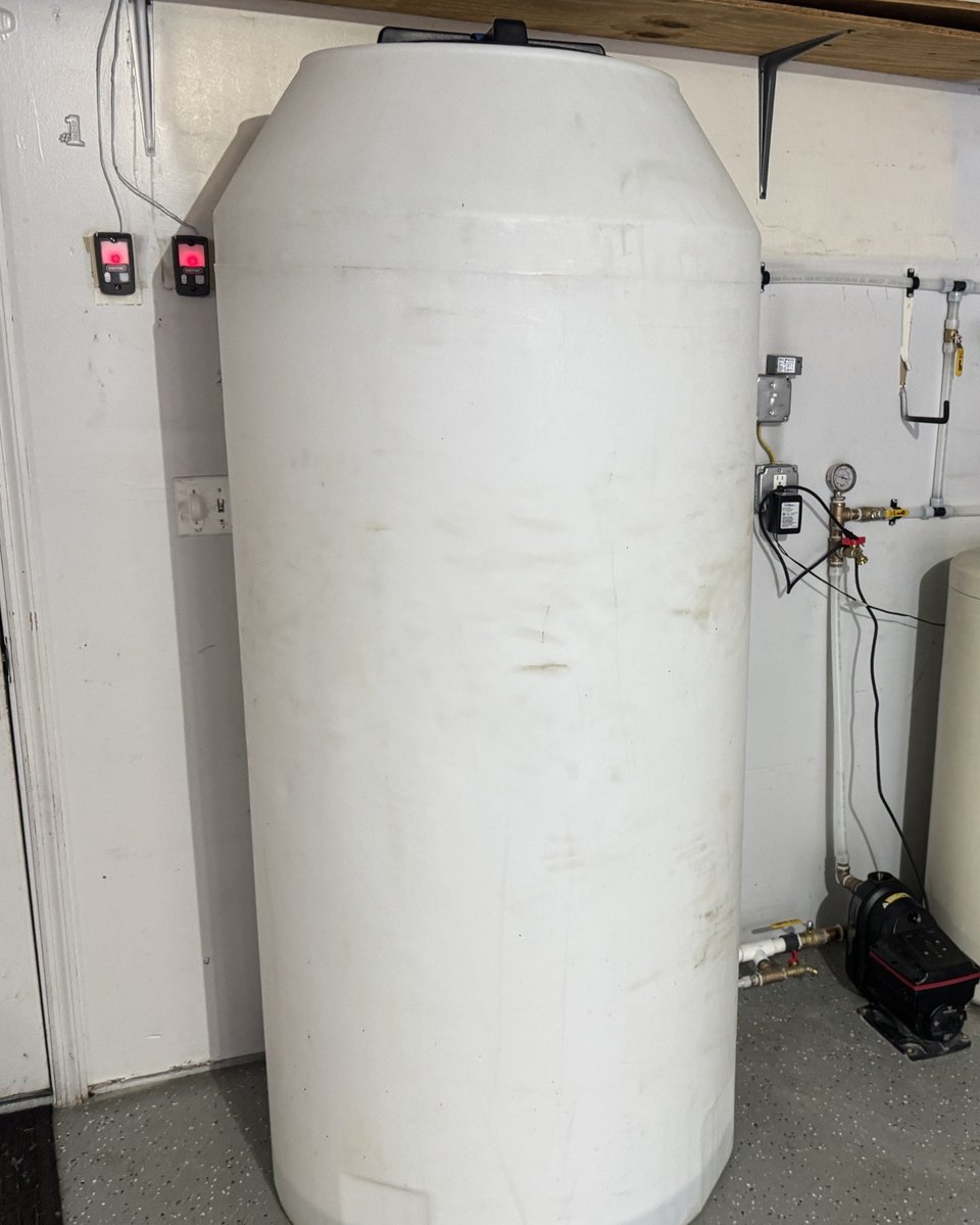 Well water storage tank with booster pump and piping